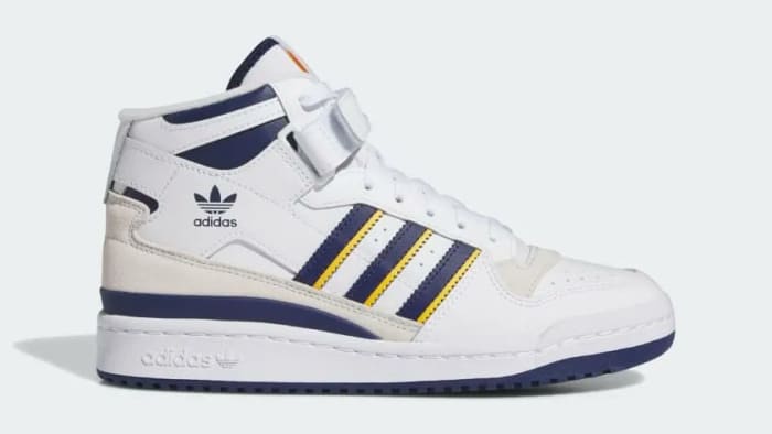 Side view of a white and navy adidas shoe.